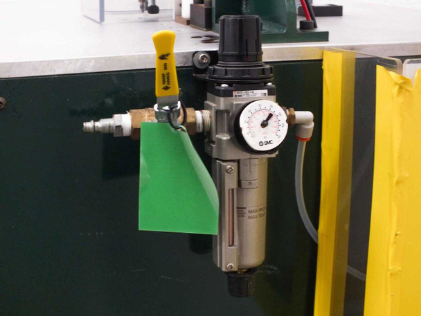 SMC AW30-N03-8Z filter/regulator unit mounted on exterior cabinet panel with pressure gauge, yellow lockout tag, and quick-connect air inlet fitting