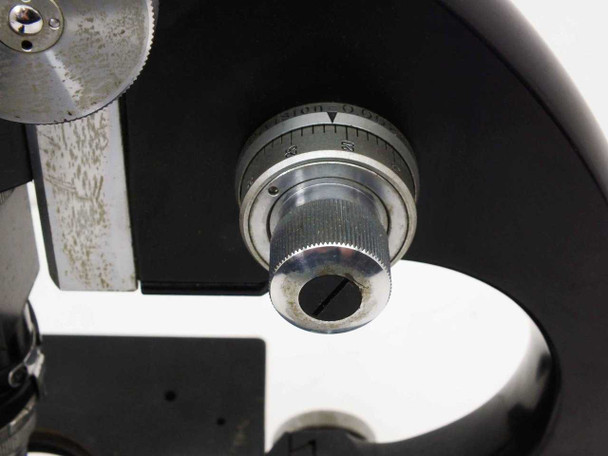 Close-up of calibrated fine focus knob with graduated dial markings; paint wear and silvering on the arm surface
