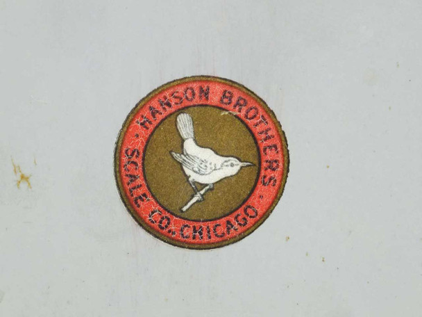 Hanson Brothers Scale Co. Chicago circular logo badge on side of scale housing – bird and red ring detail