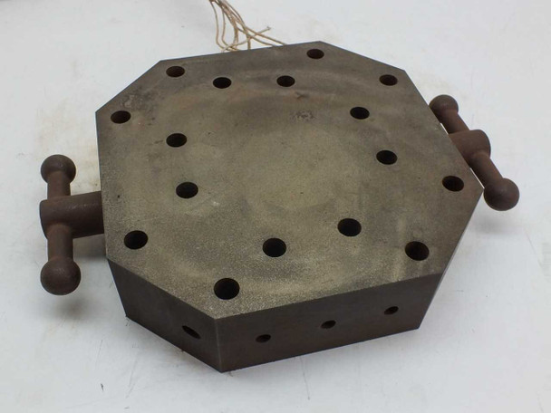Top-down view of octagonal steel heating block showing 9/16 option holes pattern and two side rod handles