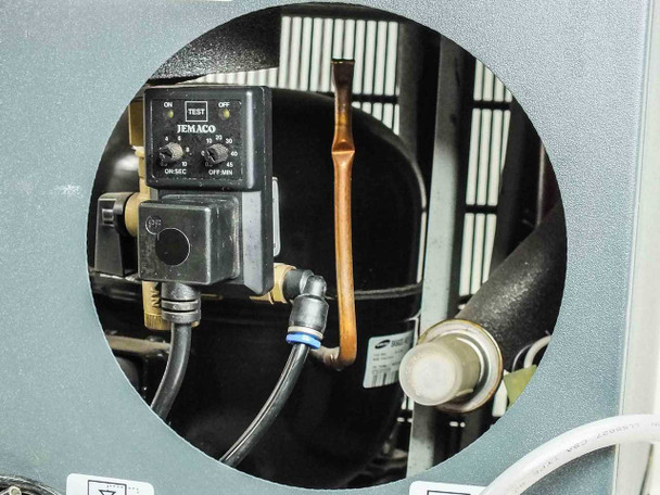 SPX Deltech HG25-115 interior access view showing Jemaco condensate drain timer module with ON/OFF/TEST dial, copper refrigerant tubing, and Samsung compressor