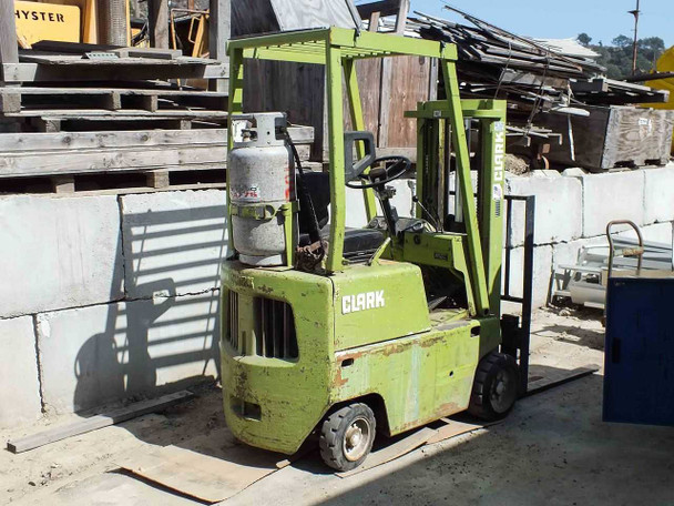 Clark C500-30 LP forklift – left side view showing green body, LP tank mounted, and mast in yard