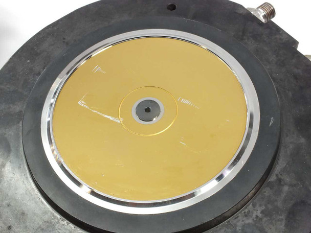 AWM Netstal injection mold head – bottom view showing gold-colored disc stamper insert seated in mold cavity with center hub and surface detail