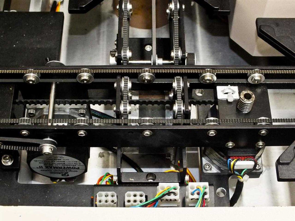 Underside of PWS P5NMS XY stage showing toothed belt drive, gear pulleys, stepper motors including Powermax II, and wiring connectors