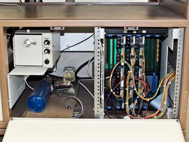 Interior cabinet of PWS P5NMS with lower bay open showing internal vacuum/pneumatic components (blue cylinder, solenoid assembly) and multi-slot electronics card cage with wiring harnesses