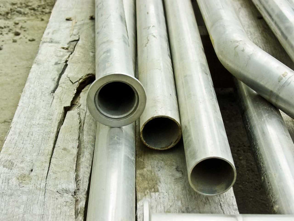 End view of stainless steel pipes resting on wood – showing 1-3/8 inch inside diameter openings clearly
