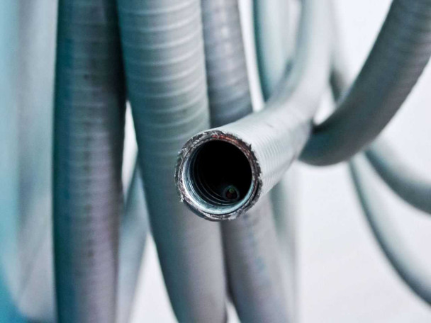 Close-up of flexible steel armored conduit coils attached to the Thermotron Console chamber controller