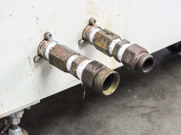 Close-up of rear threaded compression inlet and outlet fittings showing corrosion and wear on brass fittings