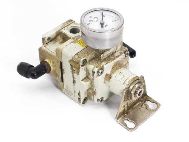 SMC IR3010-02BG pressure regulator right-side view showing mounting bracket, adjustment stem (knob missing), and yellow warning label
