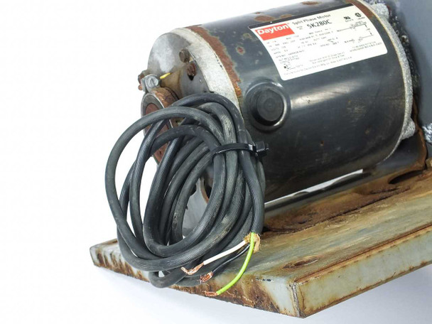 Dayton 5K280C motor side view showing attached power lead wires with bare wire ends, motor label, and rusted mounting plate