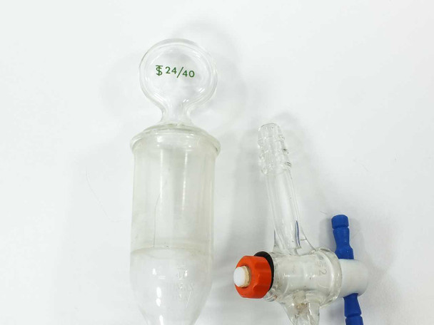 Two PTFE stopcock assemblies with orange tops and blue handles removed from glass burets — detail view