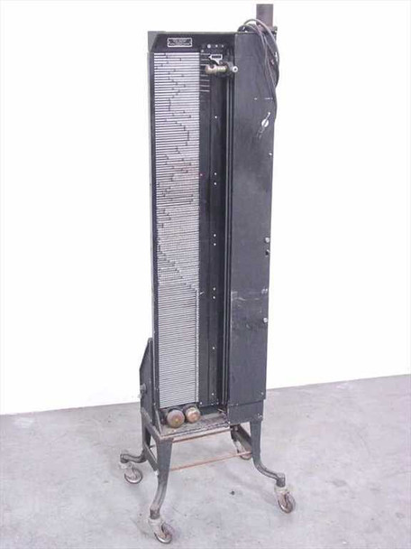 Oscar F. Carlson Depue Automatic Light Control Machine — front view showing tall black cabinet with numbered tab timing board on wheeled iron stand