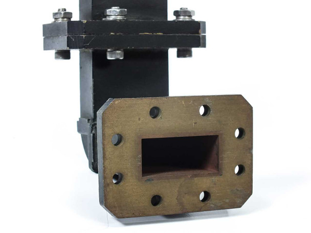 Satcom 3814402-19 WR-137 waveguide bend — close-up of dark steel flange face showing rectangular WR-137 aperture and bolt holes