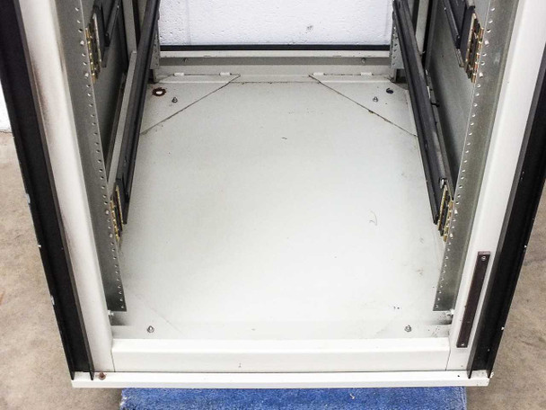 Varian VZC6967R4 cabinet floor interior – painted steel floor with open bi-fold door hinges and caster base visible