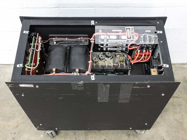 Eratron PPS 8210 RS MF – interior top view with lid open showing two large transformer/inductor cores, wiring harnesses, control board, and high-voltage warning placard