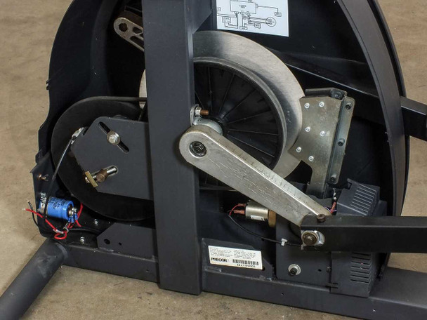 Precor EFX 5.17 drive mechanism — third angle showing flywheel, crank arm, belt assembly, wiring, and servo motor with blue capacitor