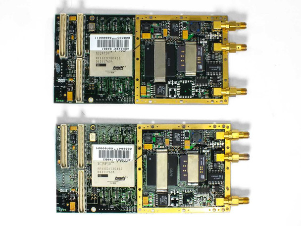 Close-up of two removed Delphi Engineering PowerPC XC2VP50 FF1152CGB0425 mezzanine processor modules showing BGA chip markings, SMA connectors, and barcode labels