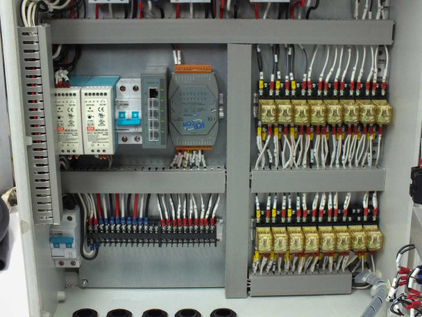Interior lower section close-up showing two Mean Well MDR-60-24 60W 24VDC DIN-rail power supplies, ICP DAS I/O module, 5-port industrial Ethernet switch, and wired terminal rows
