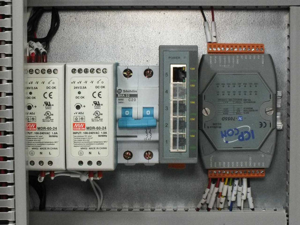 Interior right-side close-up showing Mean Well MDR-60-24 power supplies with input 100-240VAC labels, Shihlin BHA C20 circuit breaker, ICP DAS 5-port Ethernet switch, and ICP DAS M-7055D isolated DI/DO module with wired terminal connections