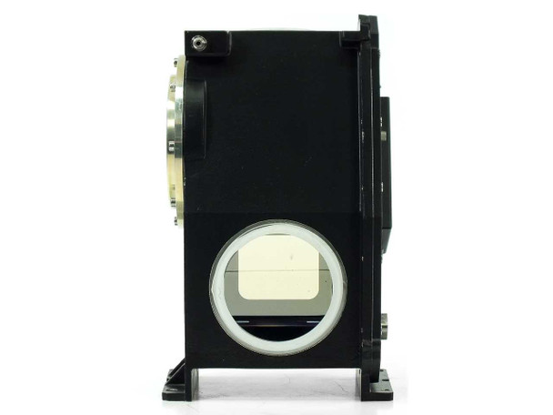 High-magnification view of prism optical surface showing scattered fine dust particles and a small surface scratch
