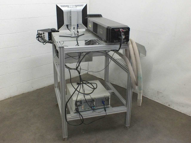 Synrad Fenix Flyer laser workstand rear view showing integrated PC tower, Dell monitor, controller box on lower shelf, cabling, and exhaust hose