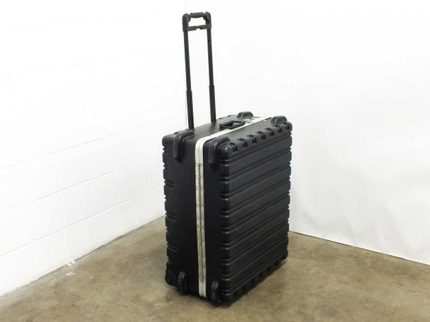Hard rolling travel case with wheels and retractable handle, closed, front-left view showing black molded plastic shell and aluminum trim