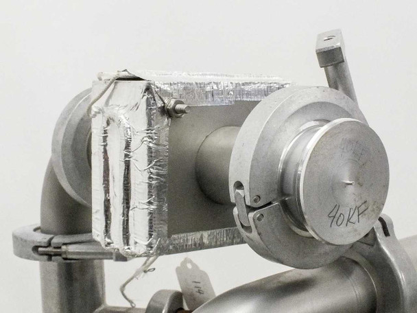 Close-up of vacuum inlet manifold showing NW clamp connections, aluminum foil tape used as temporary port seal, and handwritten '40KP' marking on fitting