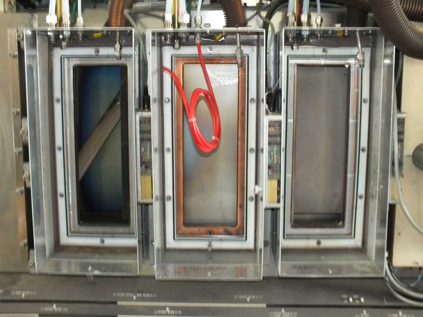 MRC 603-III three target positions viewed from front — two outer positions with blue-tinted targets, center position with DC magnetron copper target assembly and red RF cable