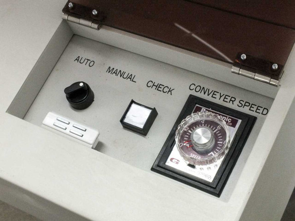 Control panel inside top cover showing AUTO / MANUAL / CHECK mode selector knob, push-button, and Panasonic CONVEYER SPEED rotary dial controller