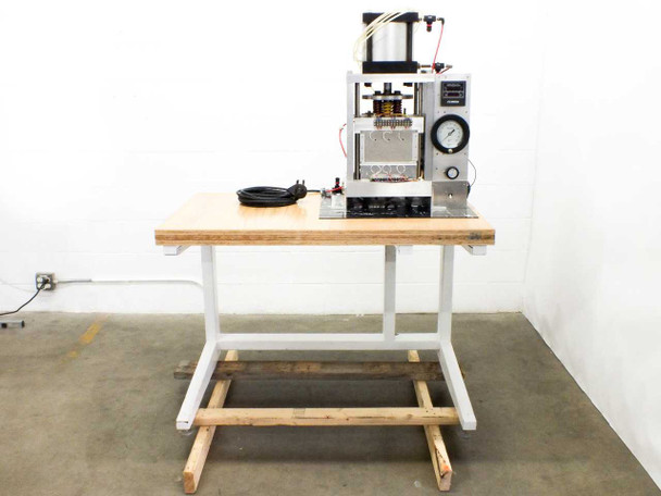 Custom heated pneumatic press on white-painted steel work table with wooden top – full front-right view