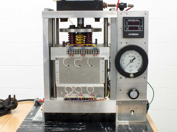 Side view showing caution electric shock label, terminal block, transformer, heat sink, and wiring on press frame