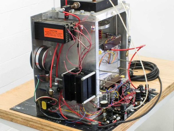Close-up of caution high-voltage label on terminal block cover with red power wiring and structural frame detail