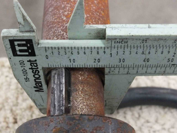 Caliper measurement of output shaft keyway cross-section – surface rust visible on shaft