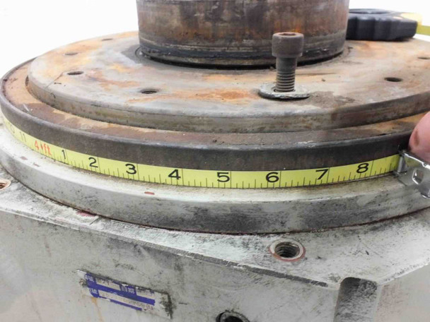 Tape measure across the top rotary output table surface showing approximately 8-inch diameter measurement