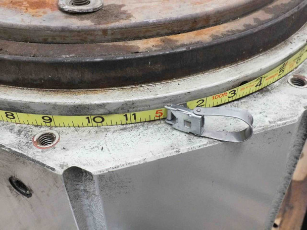 Tape measure against the side of the indexing drive table output flange showing approximately 11–12 inch diameter
