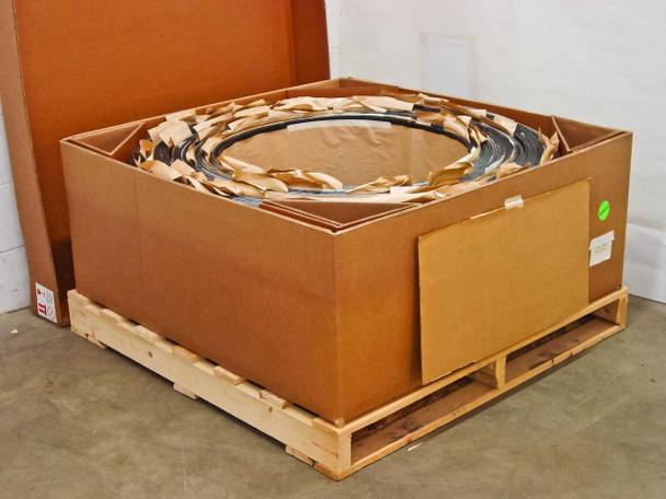Uni-Solar PVL-144 factory carton opened on pallet showing rolled flexible solar panels packed inside with kraft paper cushioning