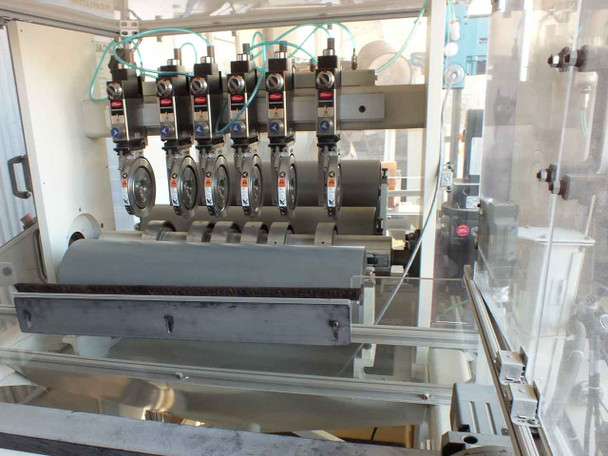 Close-up of Tidland pneumatic knife ring slitter station – six knife heads mounted over slitter roll