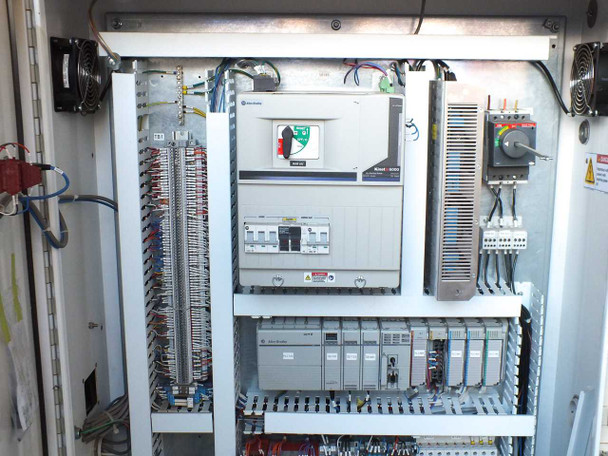 Allen-Bradley control cabinet upper section – PowerFlex drive, main breakers, PLC rack, and terminal strips