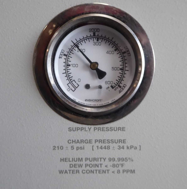 Pressure gauge close-up on Ebara CryoCompressor 4.8 showing supply pressure scale, charge pressure 210 ±5 psi, helium purity 99.995%, dew point below -80°F, water content below 8 PPM
