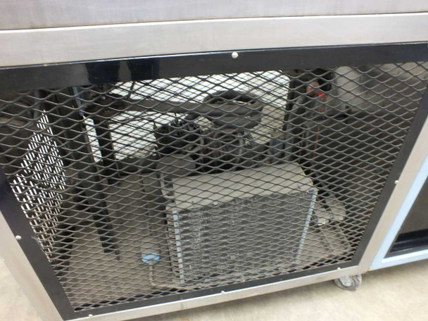 Blue M FR-256PB-1 lower section detail — refrigeration compressor unit visible through expanded-metal mesh guard