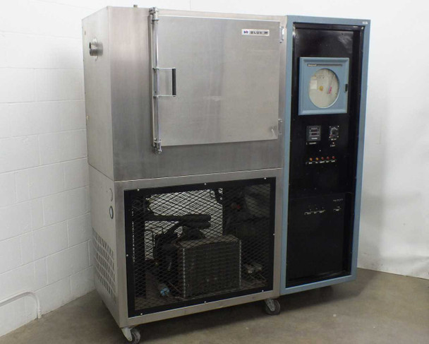 Blue M FR-256PB-1 environmental chamber — full front view showing stainless steel chamber body with large door (left), blue control cabinet with Honeywell chart recorder (right), and mesh-enclosed refrigeration compressor section below, on casters