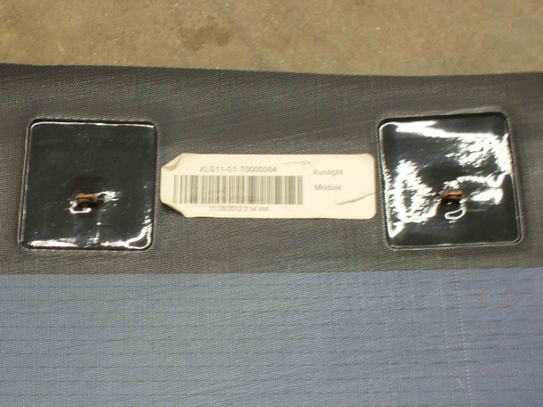 Xunlight XLS11-72 back side close-up showing two metal tab connectors and Xunlight Module product label with barcode