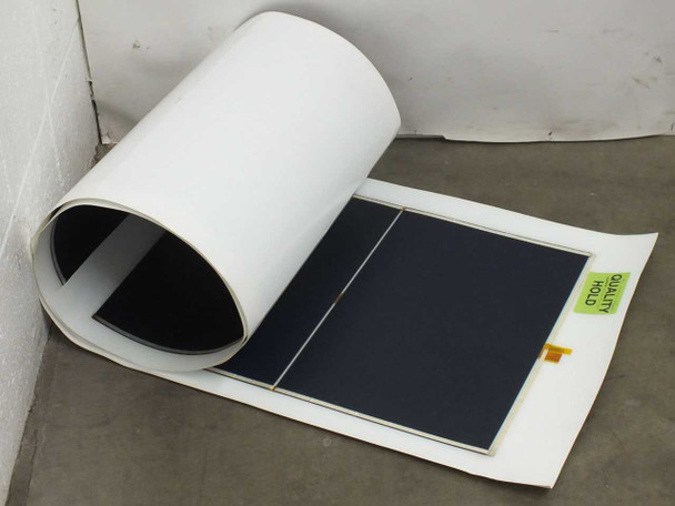 Xunlight XLS8-52 flexible amorphous solar panel partially rolled up showing ETFE top sheet and dark cell surface with Quality Hold label visible