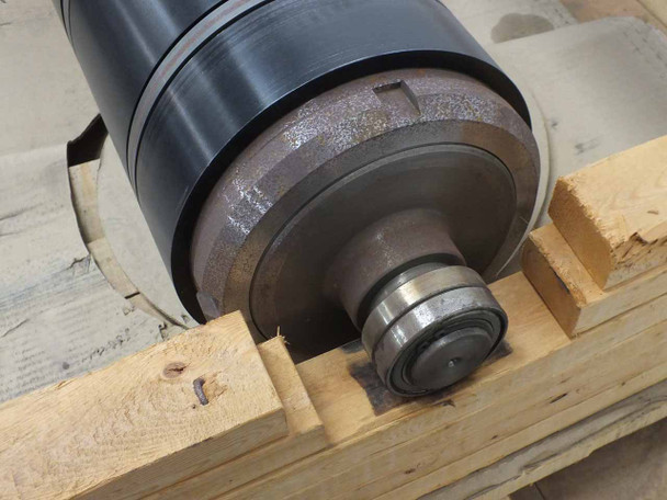 Close-up of the shaft end of the industrial press roll showing the toothed timing belt drive pulley and bearing journal