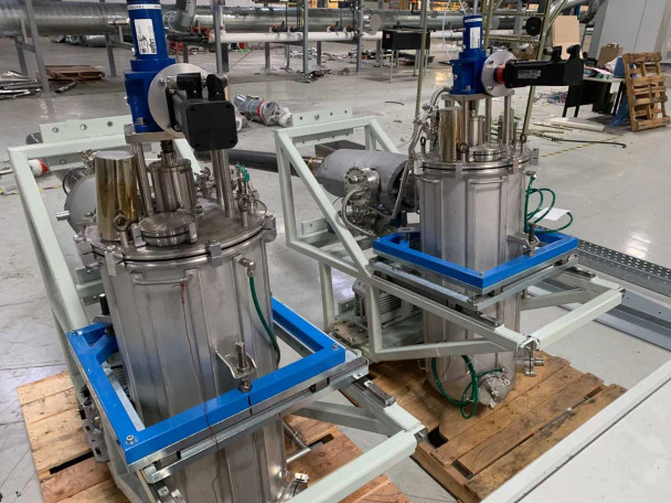 Riber Jet 40K dual stainless steel selenium reservoir vessels on blue mounting frames with actuators and vacuum fittings — close-up view