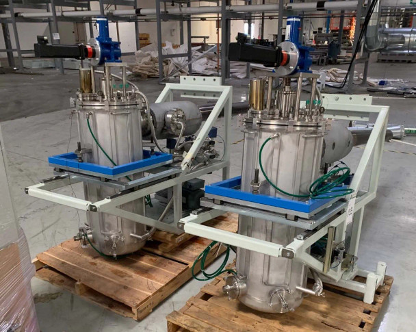 Riber Jet 40K dual selenium reservoir vessels on white steel frame close-up showing stainless flanged bodies, green tubing, and blue base plates