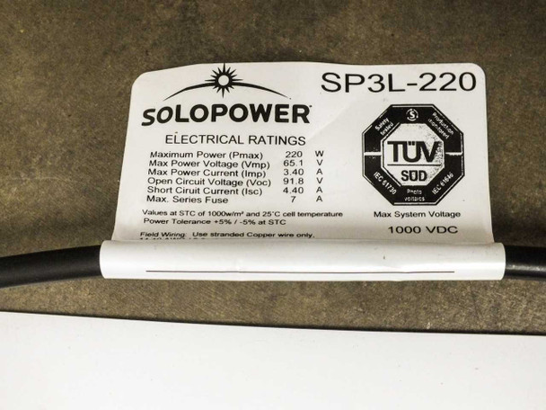 Close-up of SoloPower SP3L-220 electrical ratings label showing Pmax 220W, Vmp 65.1V, Imp 3.40A, Voc 91.8V, Isc 4.40A, Max Series Fuse 7A, Max System Voltage 1000 VDC, with TÜV SÜD certification mark