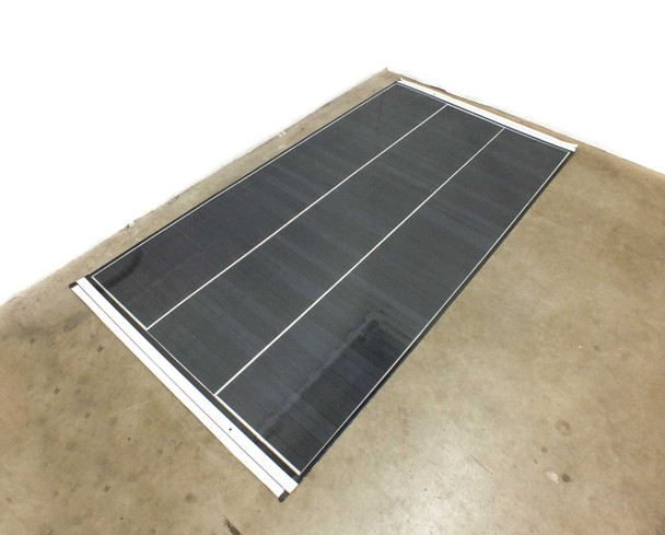 SoloPower SP3L-160 160W flexible CIGS solar panel laid flat on floor — angled overhead view showing full panel surface with three cell columns