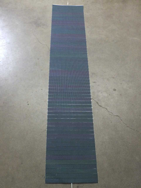 Solopower SP1 raw CIGS solar cell string laid flat on floor showing full 82-inch length and 14.5-inch width with output tabs visible at top