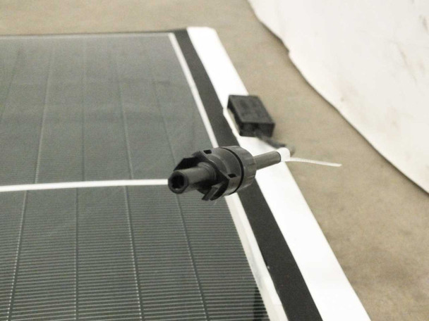 Close-up of MC4 male connector at edge of SoloPower SP3L-160 solar panel with output cable